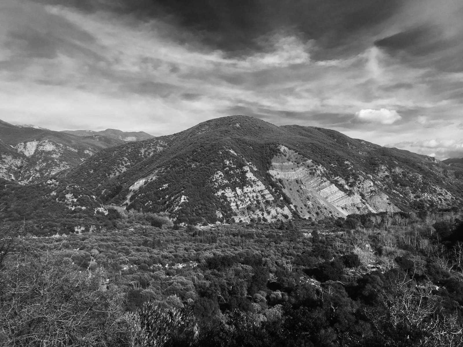 Black-and-white mountain range under a heavy bank of cloud