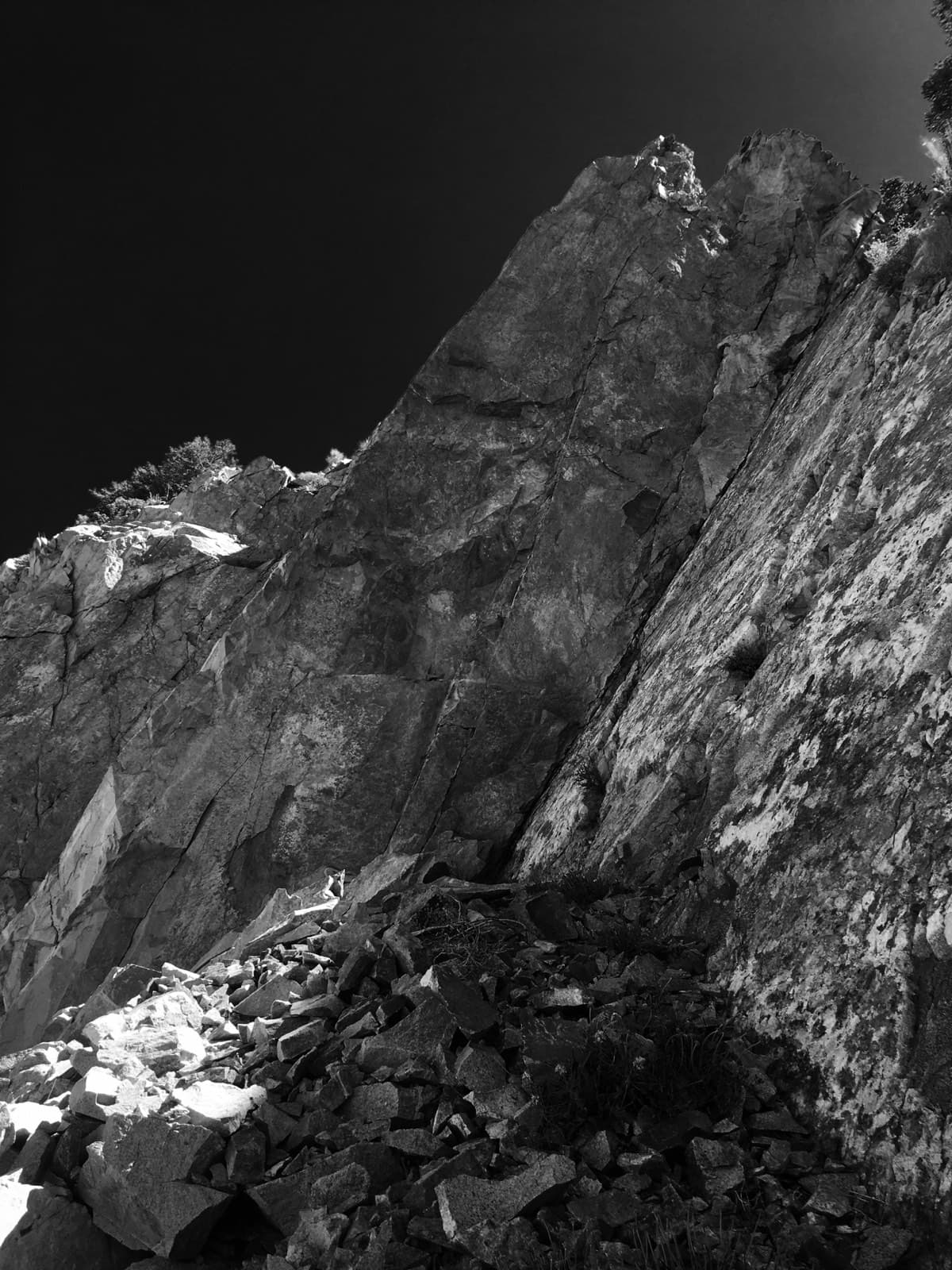 A steep rock face and scree slope, black and white