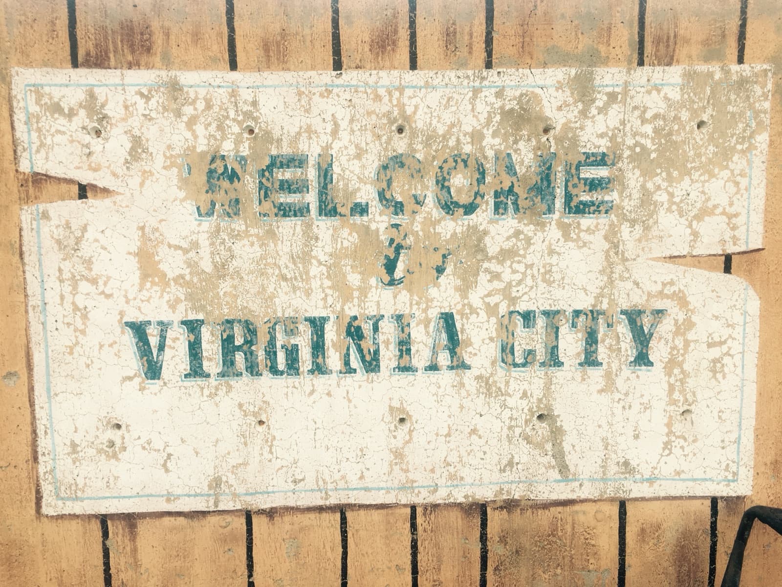 A weathered painted sign reading Welcome to Virginia City
